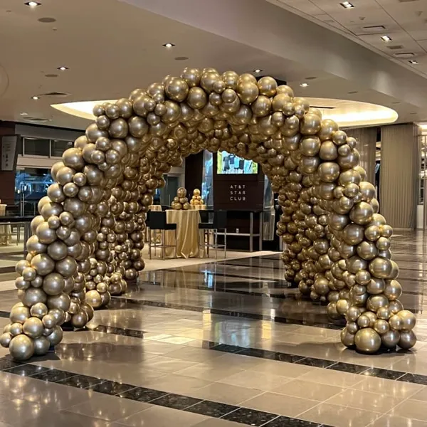 a large arch made out of gold and silver balls in a lobby of a hotel or a shopping center
