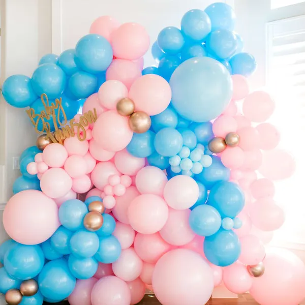 a bunch of balloons that are sitting on a table in front of a window with a happy birthday sign on it