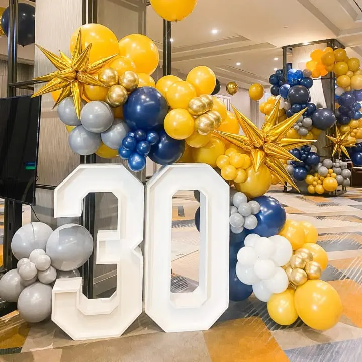 a large number of balloons and balloons in the shape of the number 50 are on display in the lobby of a hotel