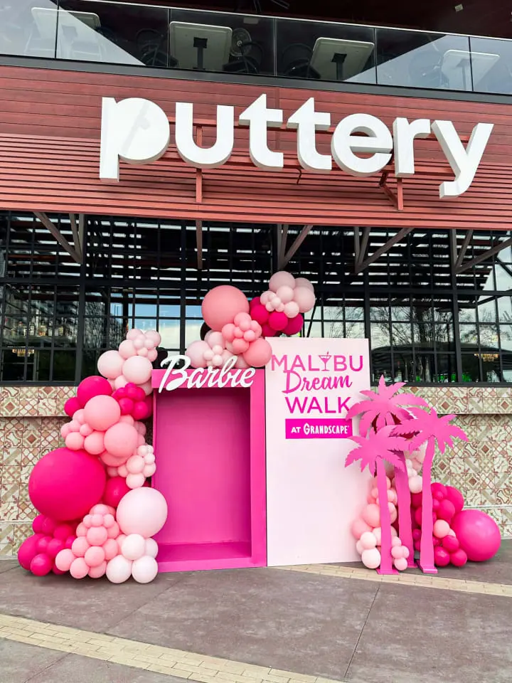 a display of pink and pink balloons in front of a storefront with a sign that says buttery