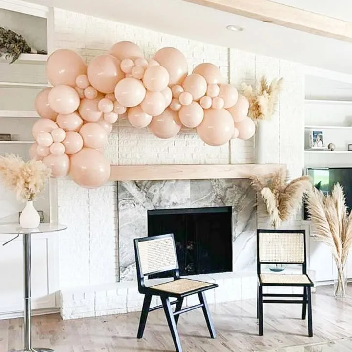 a living room filled with a fire place and a bunch of balloons hanging from the ceiling over a fireplace