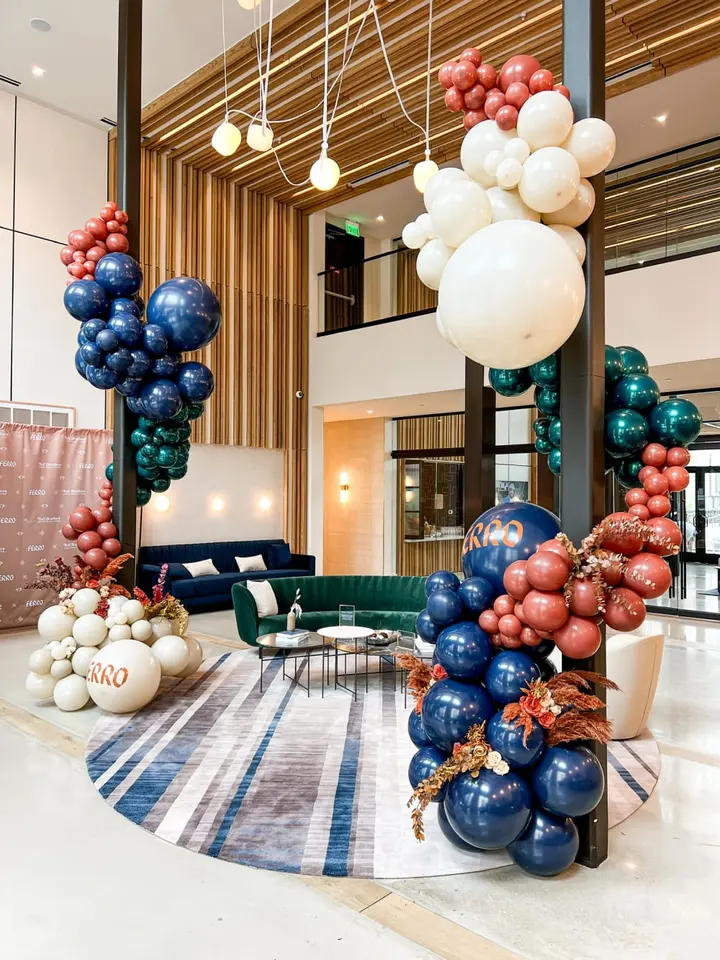 A modern and vibrant lobby space with colorful balloon installations, plush seating, and a patterned floor, creating an inviting and visually striking atmosphere.