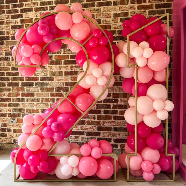 a number made out of balloons in the shape of the number twenty two in front of a brick wall