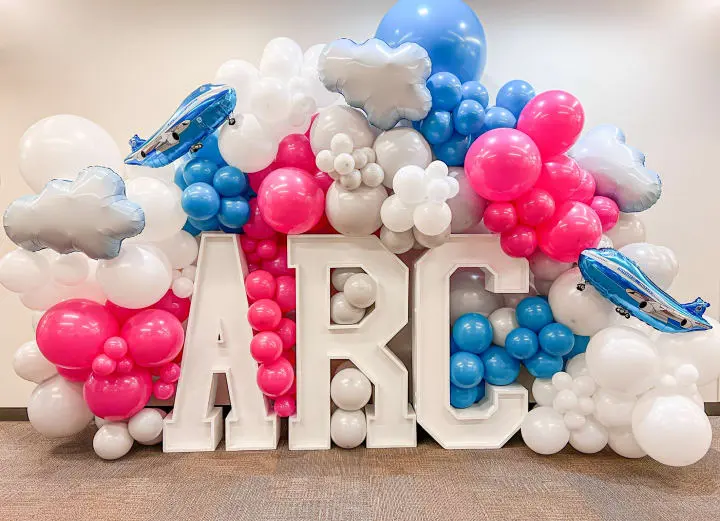 a bunch of balloons that are in the shape of the letters arg and a plane on top of it