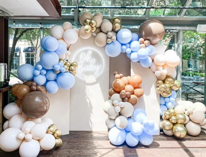 a large balloon arch with balloons in the shape of the letter e on a wall in a lobby of a building