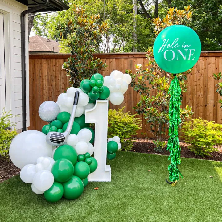 a lawn decorated with balloons and a sign that says make me one with a fork and a spatula