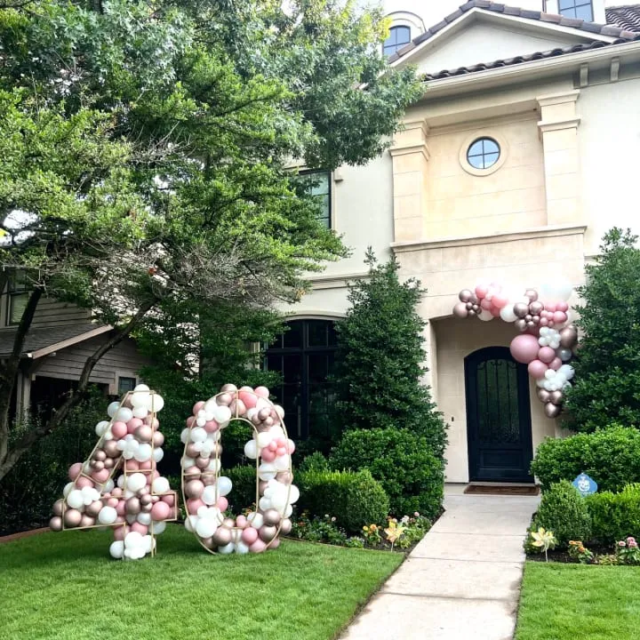 a house with a lawn decorated with balloons and the word love spelled out in front of the front yard