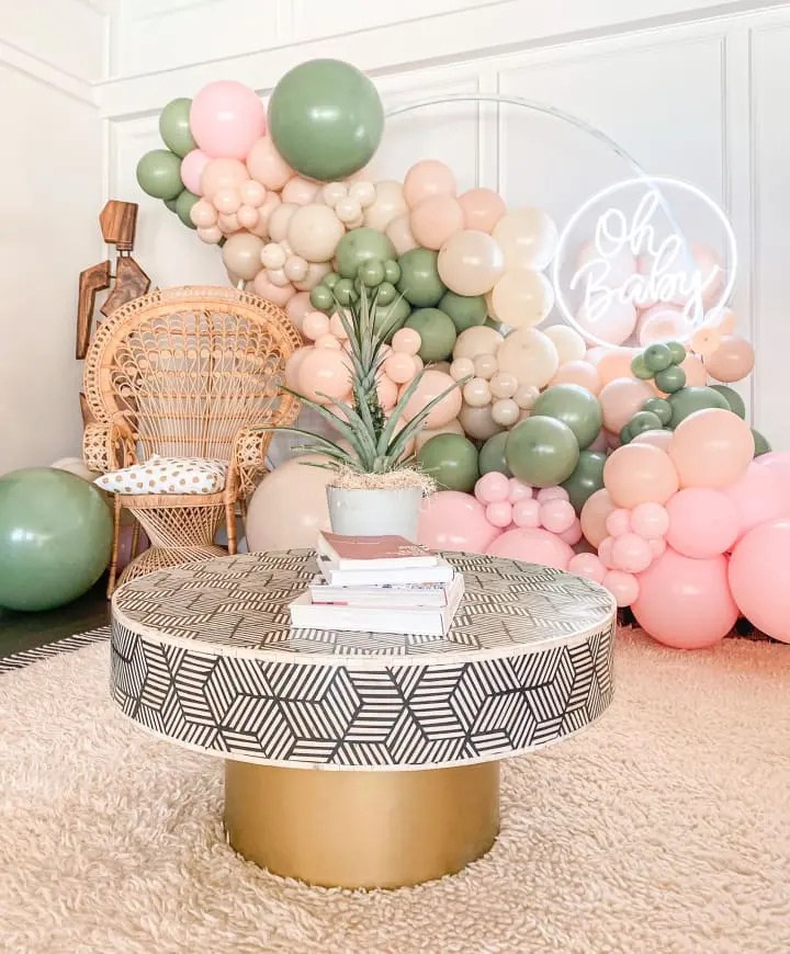 a room filled with balloons and a table with a potted plant on top of a round coffee table