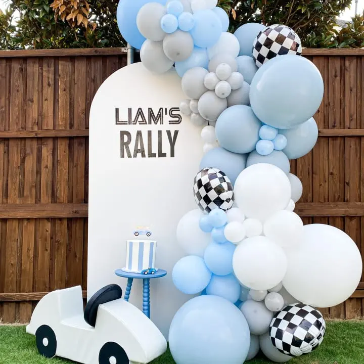 a balloon arch with balloons and a toy car in front of a sign that says llamas rally