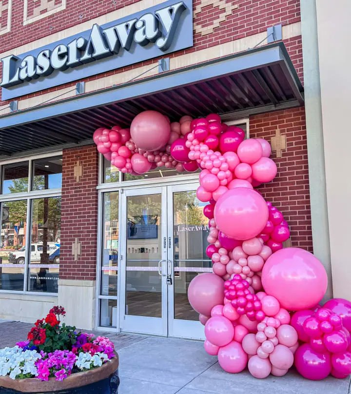 a bunch of balloons that are on the side of a building with a sign that says laseraway on it