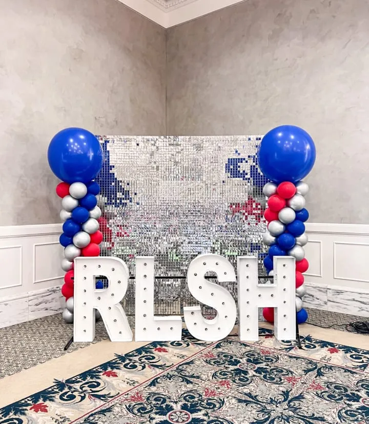 a room with balloons and a sign with the word fresh on it in front of a carpeted area