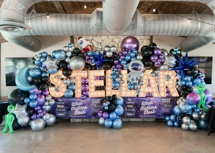 a large balloon display in the shape of the word steal surrounded by balloons and streamers in a building