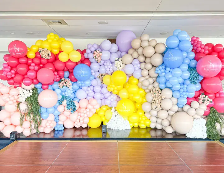 a room filled with lots of balloons and a wall with a large number of balloons hanging from it's sides