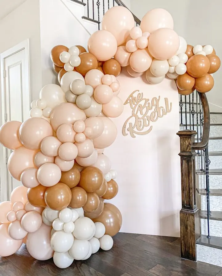 a bunch of balloons that are on the ground in front of a stair case and a staircase case in the background