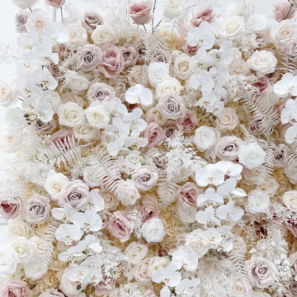 The image features a large, white, and pink rose wall with a variety of white flowers, including roses, scattered throughout the scene.