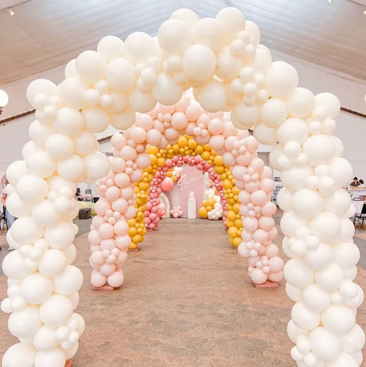 a large arch made out of balloons in a room with a ceiling fan and a ceiling fan in the background