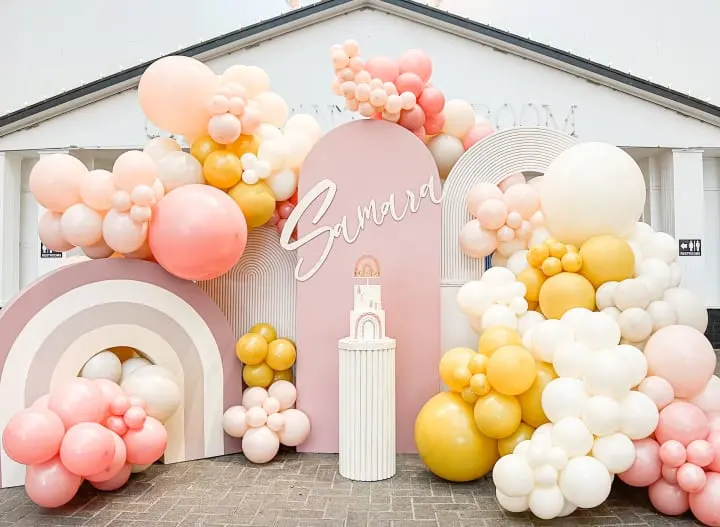 a bunch of balloons that are on the ground in front of a building with a sign that says gwayu on it