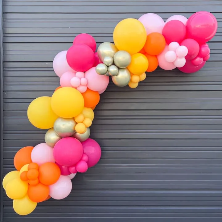 a bunch of balloons hanging from a garage door in front of a garage door with a number of balloons attached to the side of the door