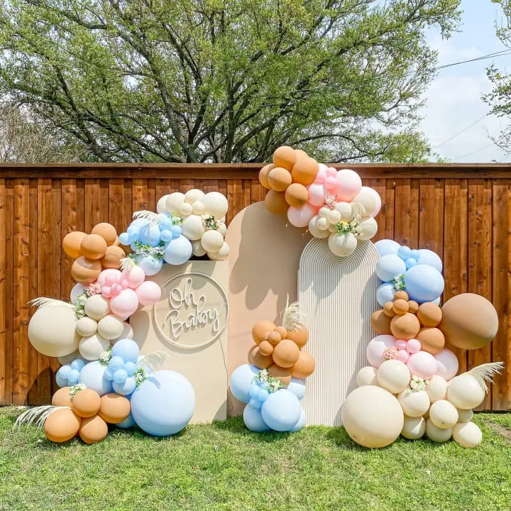 a large balloon arch in the shape of a house with balloons attached to it and a sign that says welcome home
