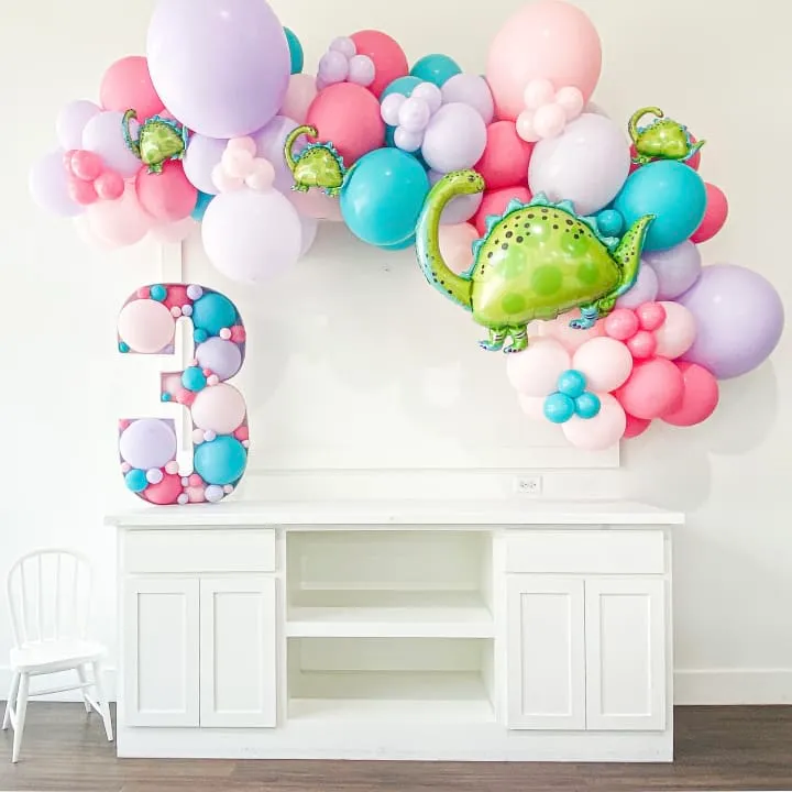 a room filled with balloons and a wall mounted to the side of a wall with a green teapot on top of it