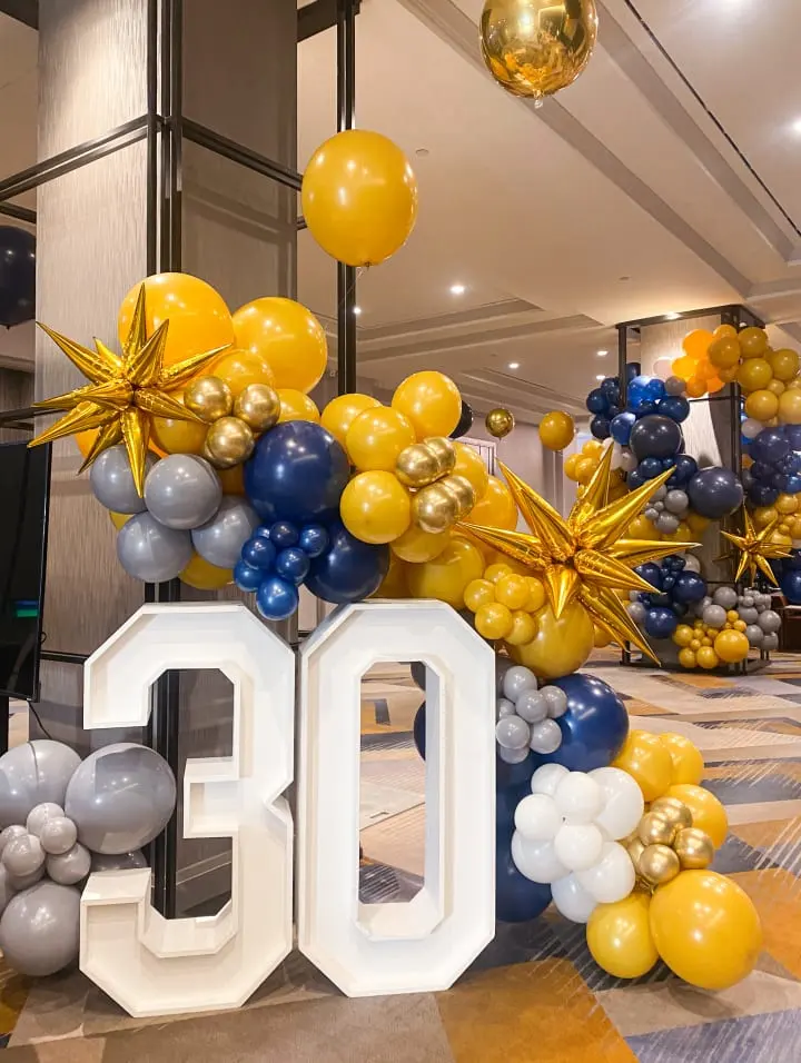 a large number is surrounded by balloons and streamers in the shape of the number thirty thirty and the number thirty