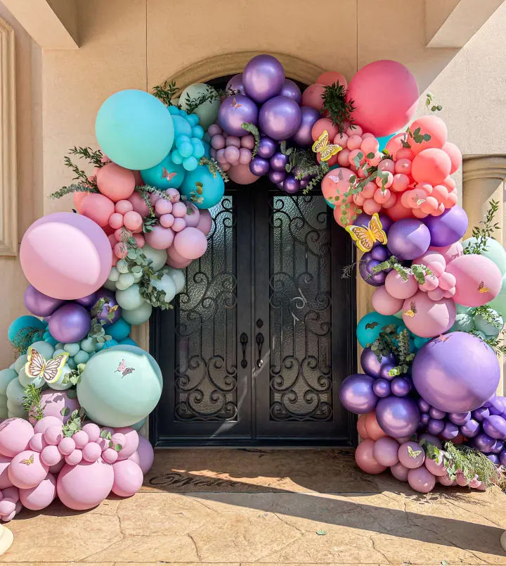 a bunch of balloons that are in front of a door that has a bunch of balloons on it and a bunch of flowers on the outside of the door