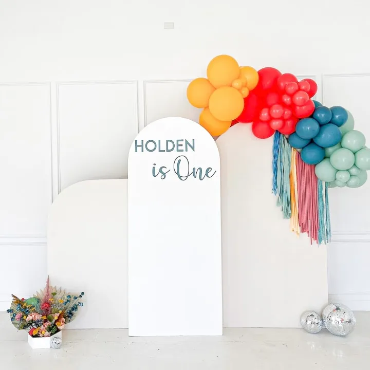 a balloon arch with a sign that says,'holiday is one'and a bunch of balloons behind it