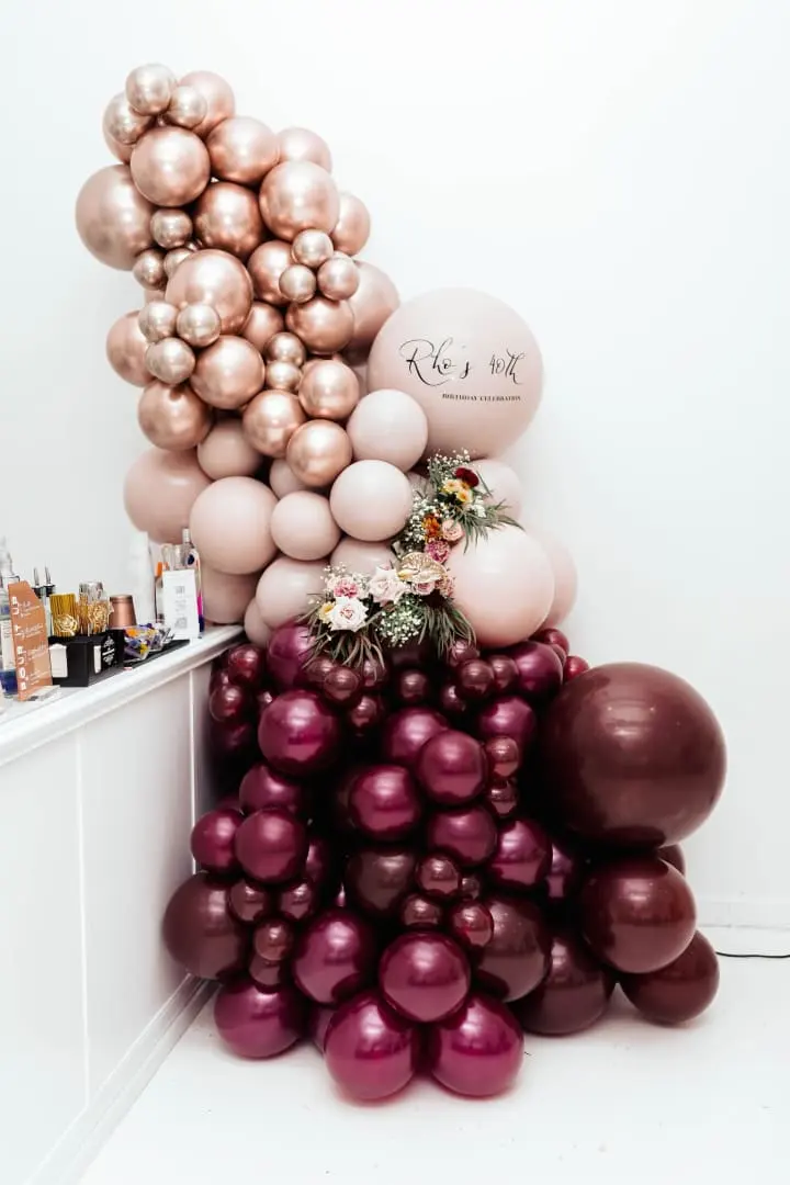 a bunch of balloons are stacked on top of each other in a room with white walls and flooring