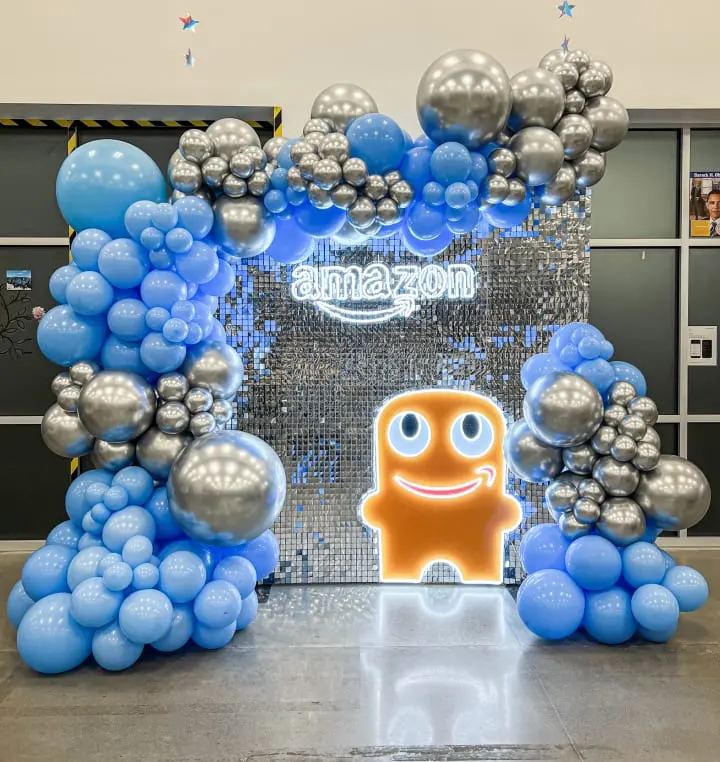 a bunch of balloons that are in the shape of a gate with a smiling face on it and a amazon logo on the front of the gate