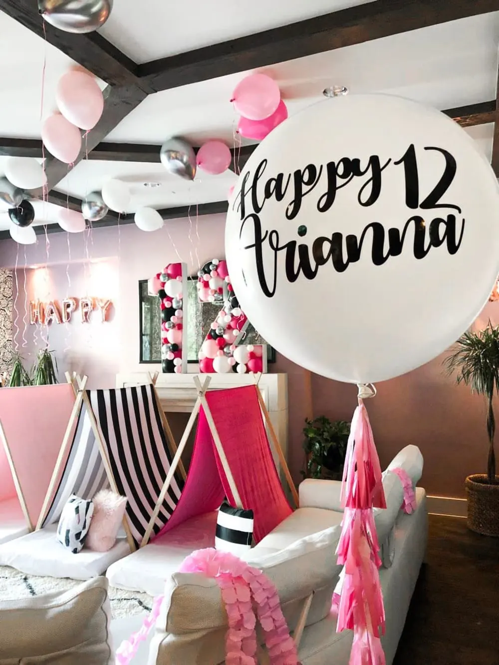 a room filled with lots of balloons and a sign that says happy fivania on the front of the room