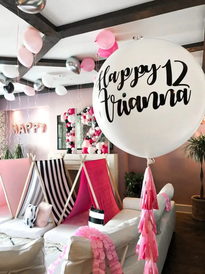 a room filled with lots of balloons and a sign that says happy fivania on the front of the room