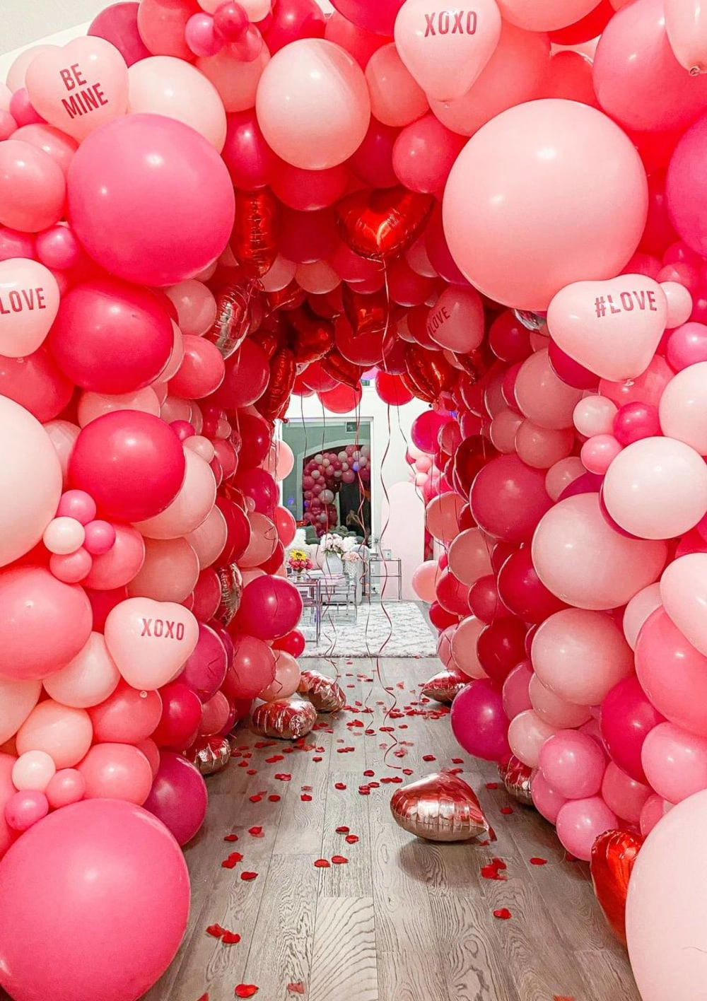 a bunch of balloons that are on the ground in a room with a wooden floor and a wooden floor