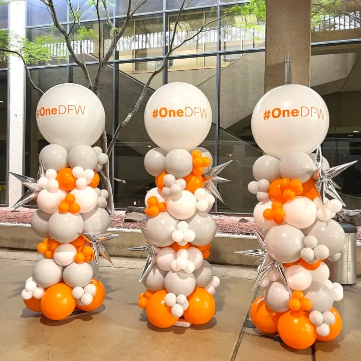 a bunch of balloons that are sitting on the ground in front of a building with a one df logo on it