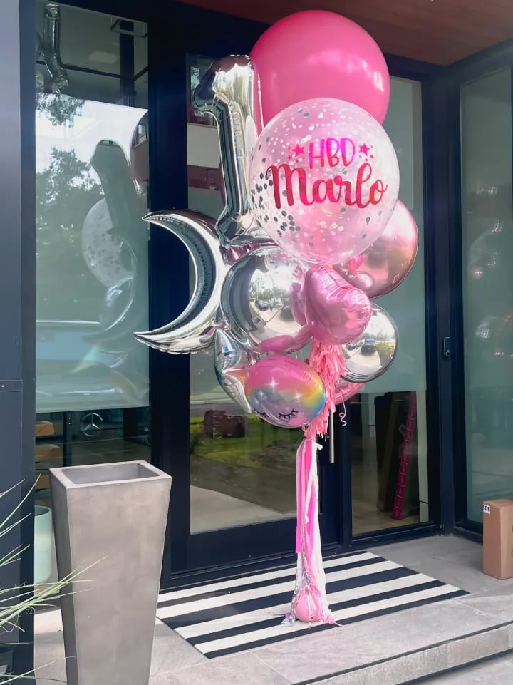 a bunch of balloons that are in front of a store front door with the words hello moon on it