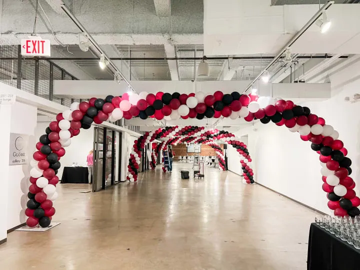 a long hallway with a bunch of balloons on the wall and a sign that says exit on the wall