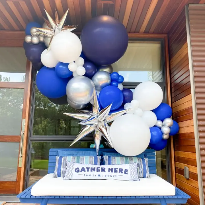 a bunch of balloons that are on top of a blue and white box on a table in front of a building