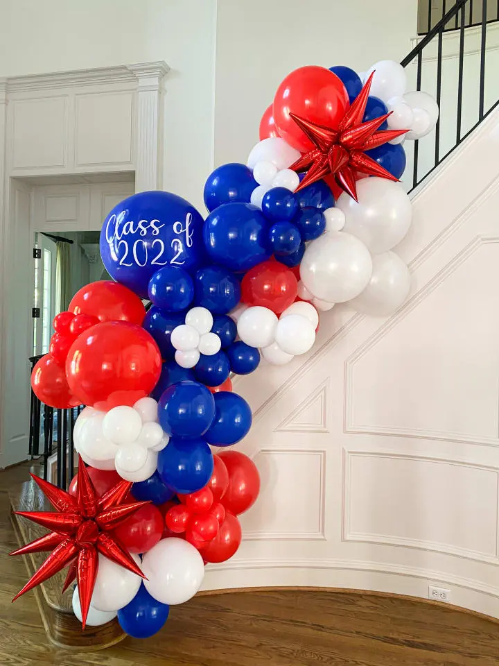 a bunch of red, white and blue balloons are on the stairs of a house with a star decoration