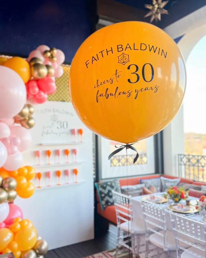 an orange balloon with the number 30 on it is in the middle of a room filled with tables and chairs