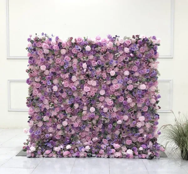 a purple flowered wall in a room with a potted plant on the floor and a white wall behind it