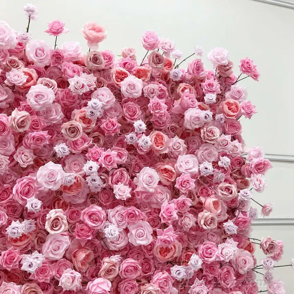 a bunch of pink flowers are hanging on a wall in front of a garage door with a white wall behind it