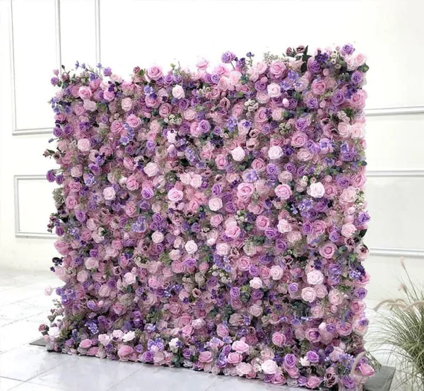 a large purple flowered wall in front of a white wall with a potted plant next to it
