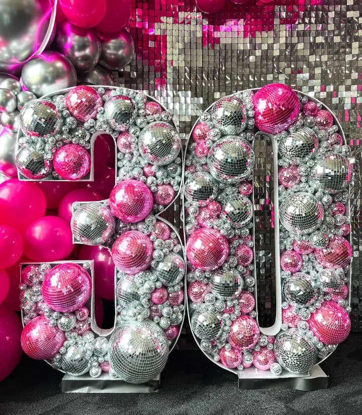 a large number of pink and silver balloons in front of a large number of silver and pink balloons in the background