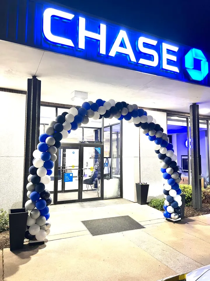 a chase bank entrance decorated with balloons and a blue and white arch with the chase bank logo on it