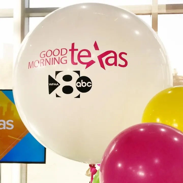 a bunch of balloons that are in front of a sign that says good morning teas and a balloon with a cat on it