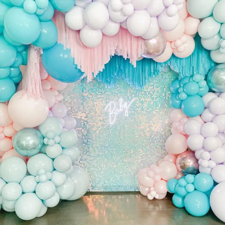 a backdrop of balloons and streamers with a blue and white backdrop and a pink and white backdrop and a blue and white backdrop