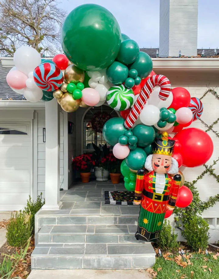 a large balloon arch with a nutcracker and candy canes on it in front of a house
