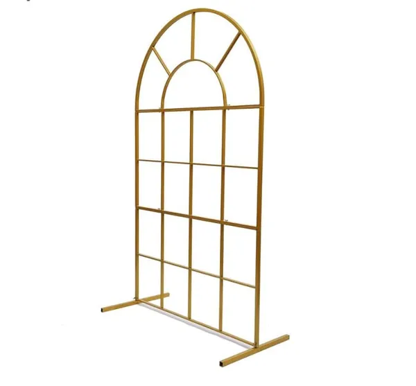 A small, gold-colored metal shelf with a decorative arched design is placed on a white background, creating a visually appealing and unique display.