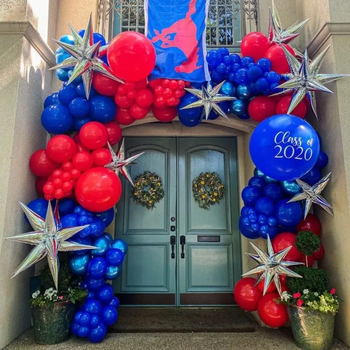 a door decorated with balloons, stars, and wreaths for a new year's eve celebration in front of a building