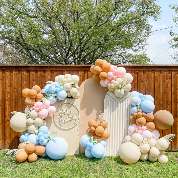 a large balloon arch in the shape of a house with balloons attached to it and a sign that says happy birthday