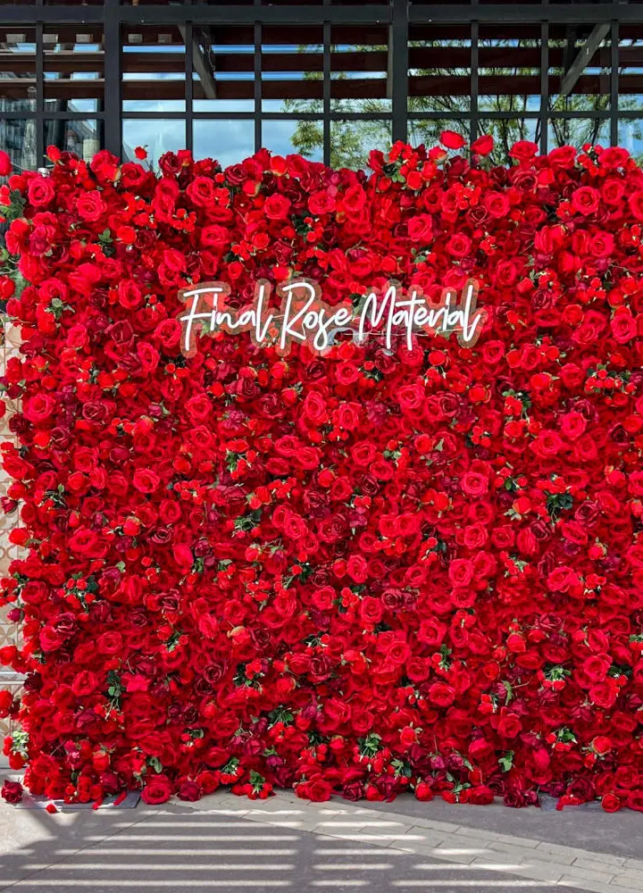 A large, vibrant red floral wall with the text "From Rose Matter" prominently displayed, set against a backdrop of glass and steel structures.